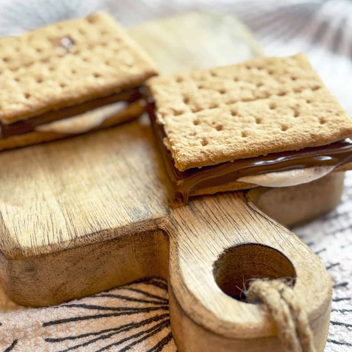 Air fryer s’more with melted marshmallow oozing out the sides and chocolate dripping.