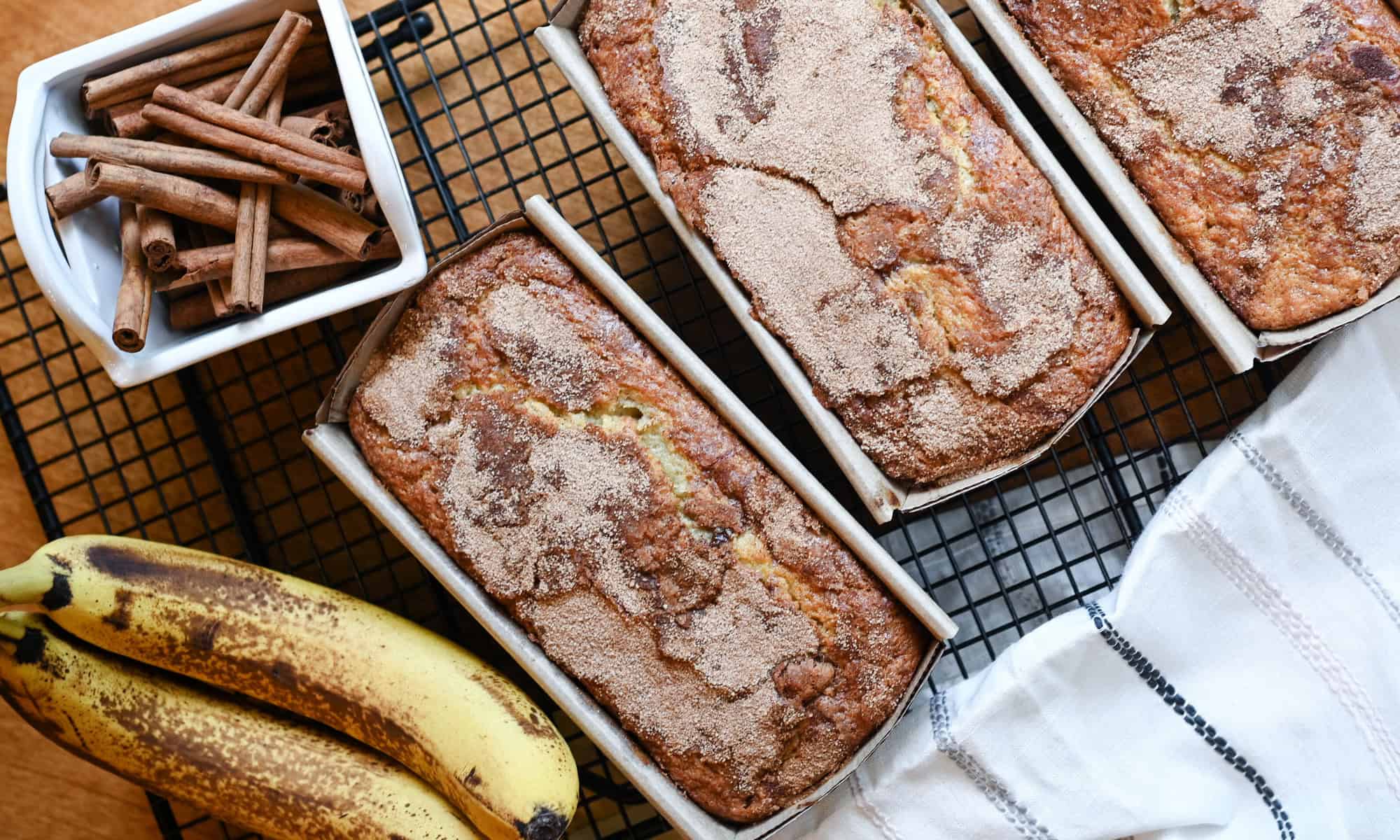 Loaves of Banana cinnamon swirl bread on a cooling rack ready to cut