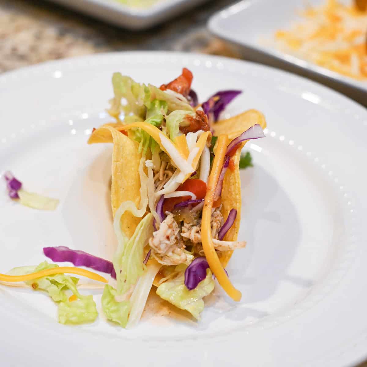 Chicken verde taco topped with fresh garnishes in a warm tortilla