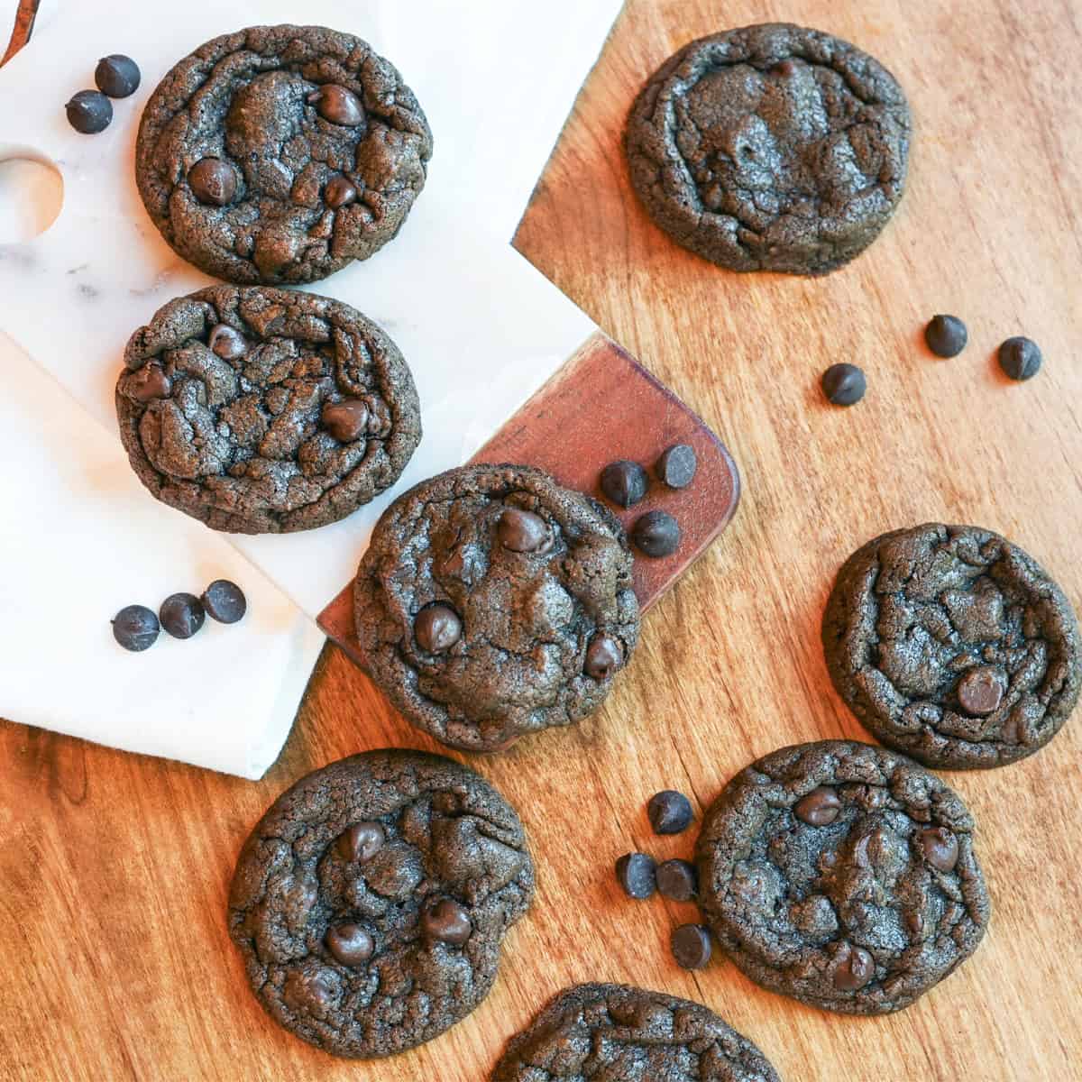 Freshly baked chocolate chocolate chip cookies arranged on a cooling rack