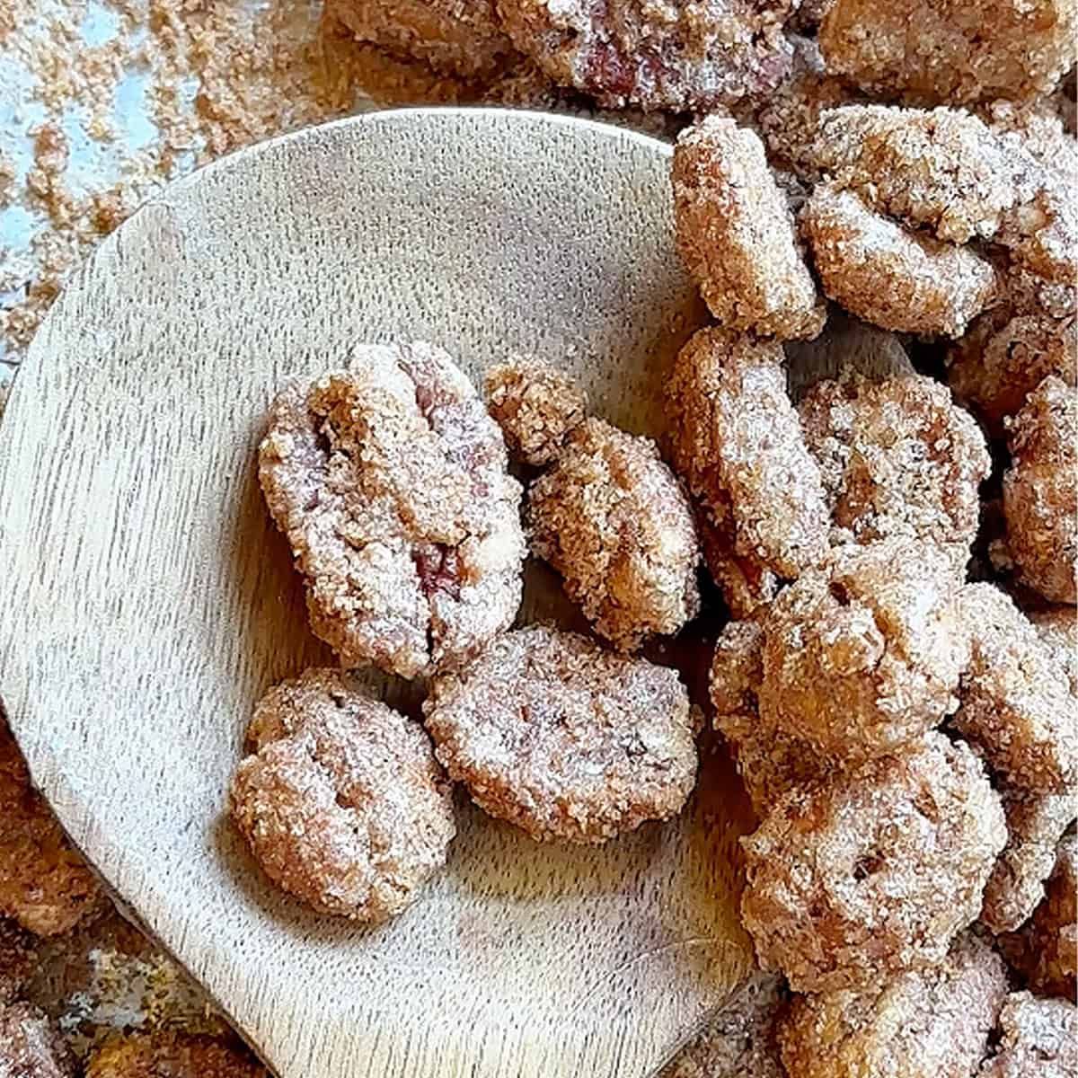cinnamon sugar pecans on a wooden spoon