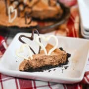 Creamy Hershey Bar Pie with chocolate hearts on top and a flaky pie crust, showing the smooth, rich chocolate filling.