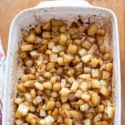 Oven roasted potatoes in a white baking dish, golden and crisp.