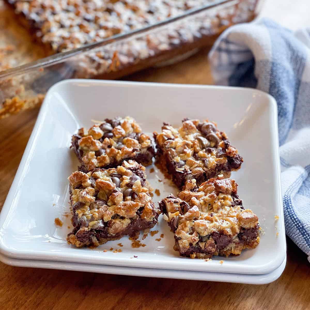 Freshly baked Magic Cookie Bars stacked on a white plate.