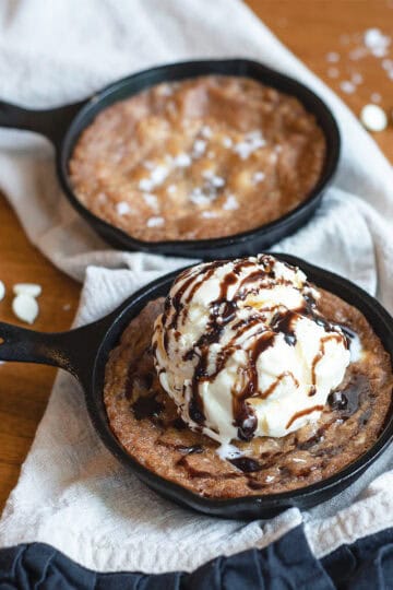 Overhead shot of a white chocolate macadamia nut skillet cookie with a scoop of ice cream in the center.