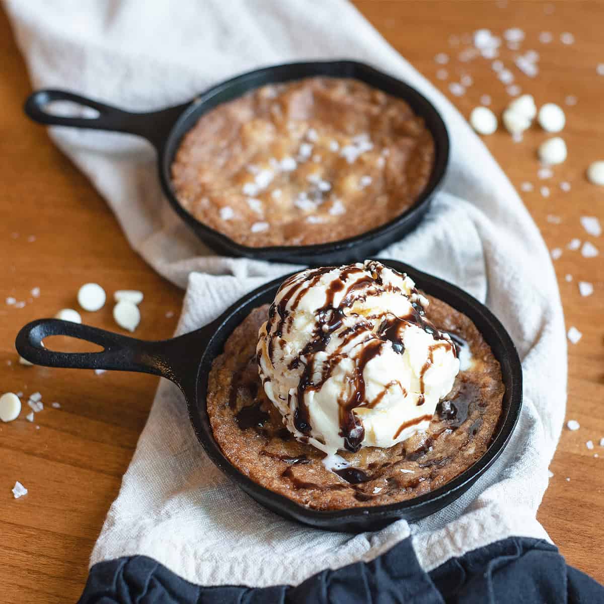 Overhead shot of a white chocolate macadamia nut skillet cookie with a scoop of ice cream in the center.