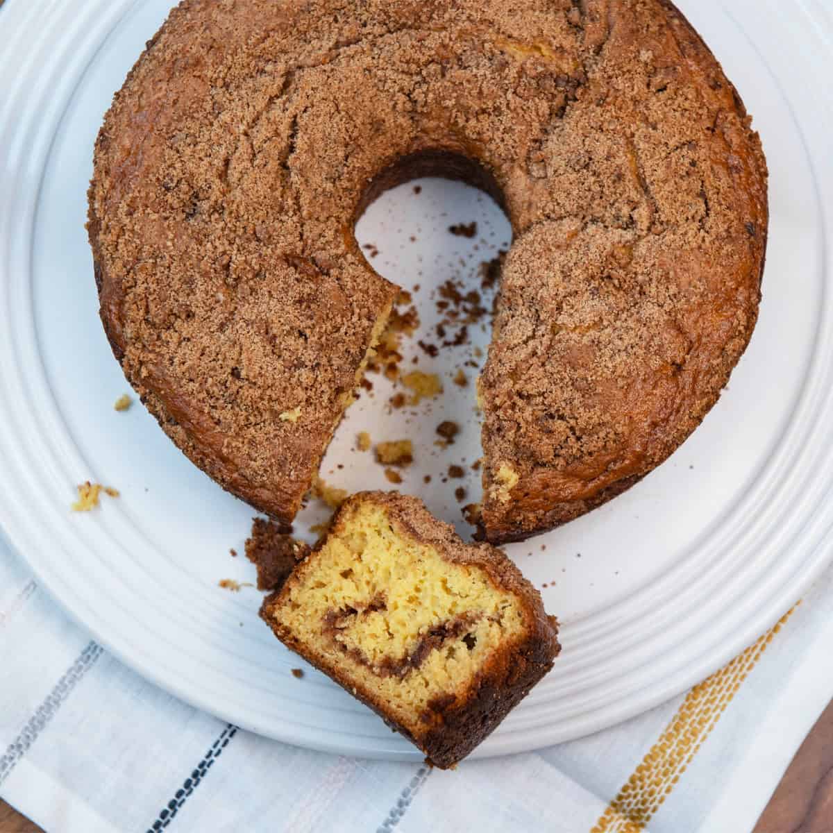 cinnamon crumb cake with a rich cinnamon swirl and crumb topping on a white platter.