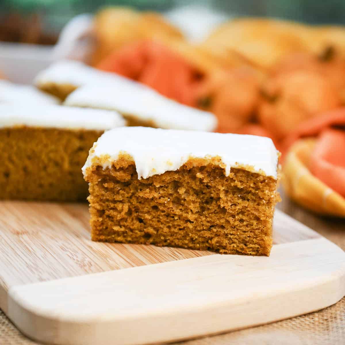 Close-up of a pumpkin bar slice showing moist texture and cream cheese frosting