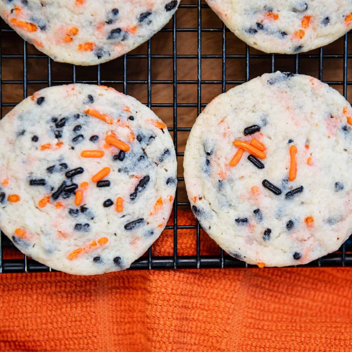 Overhead view of Halloween sprinkle cookies lined up neatly on a cooling rack.