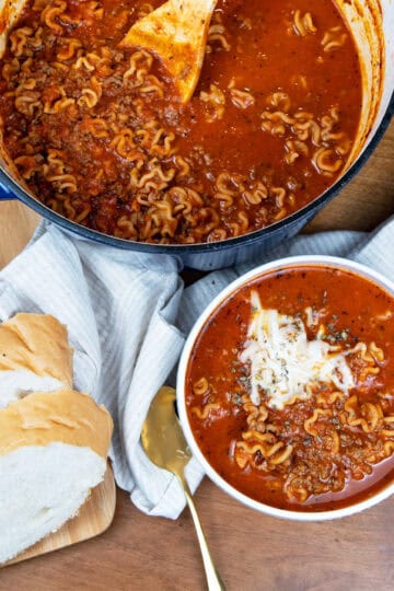 Overhead view of a pot of lasagna soup with a full bowl beside it, ready to serve
