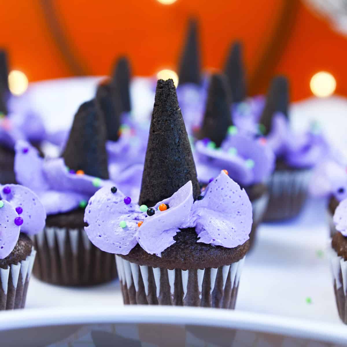 Chocolate cupcake topped with purple buttercream and a waffle cone hat for Halloween.