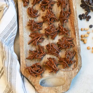 No-bake chocolate haystacks made with chow mein noodles, stacked in clusters on parchment paper.
