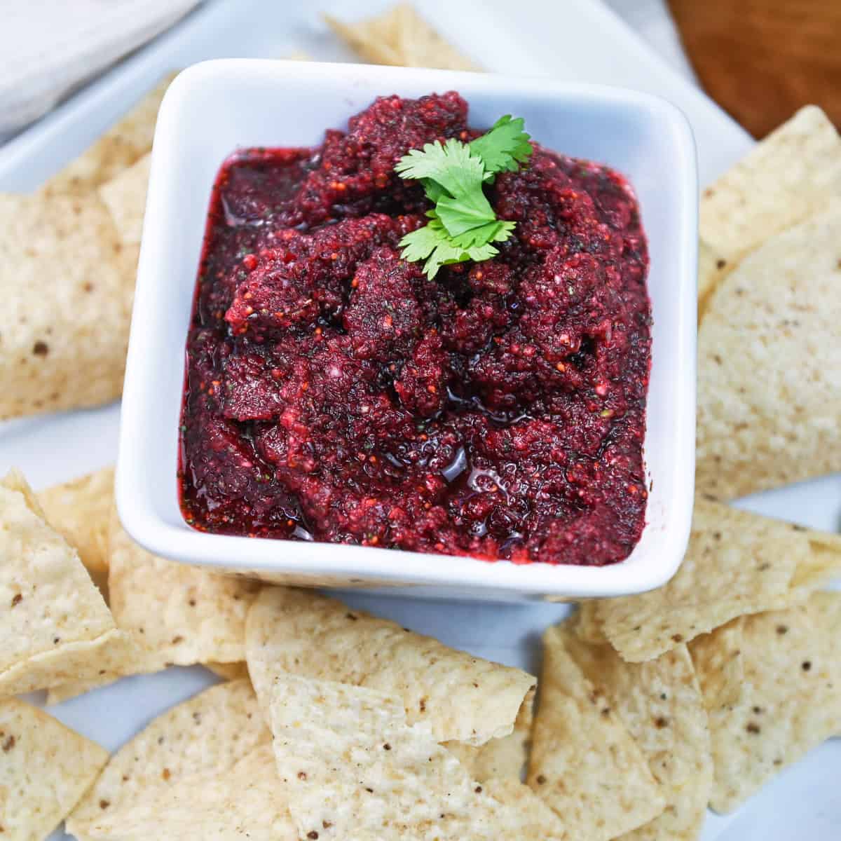 Overhead image of a bowl of cranberry salsa served with tortilla chips