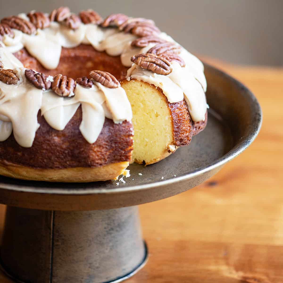 Butter bundt cake with praline glaze and a slice removed to show the moist inside