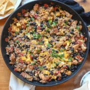 chicken burrito in a skillet with beans and rice