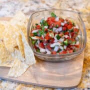 Small bowl of fresh pico de gallo served with a few tortilla chips in a bowl
