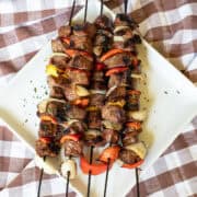 Grilled steak kabobs with colorful bell peppers and onions on skewers.