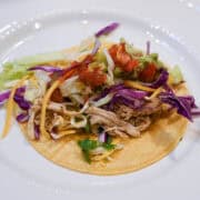 Crockpot chicken verde served in tacos with fresh toppings Caption: Tender slow cooker chicken verde piled into warm tacos for an easy, flavorful meal. Description: Juicy shredded chicken verde made with salsa verde and slow-cooked chicken breasts served in soft tacos and topped with fresh garnishes, perfect for a quick dinner, meal prep, or family-friendly weeknight meal.