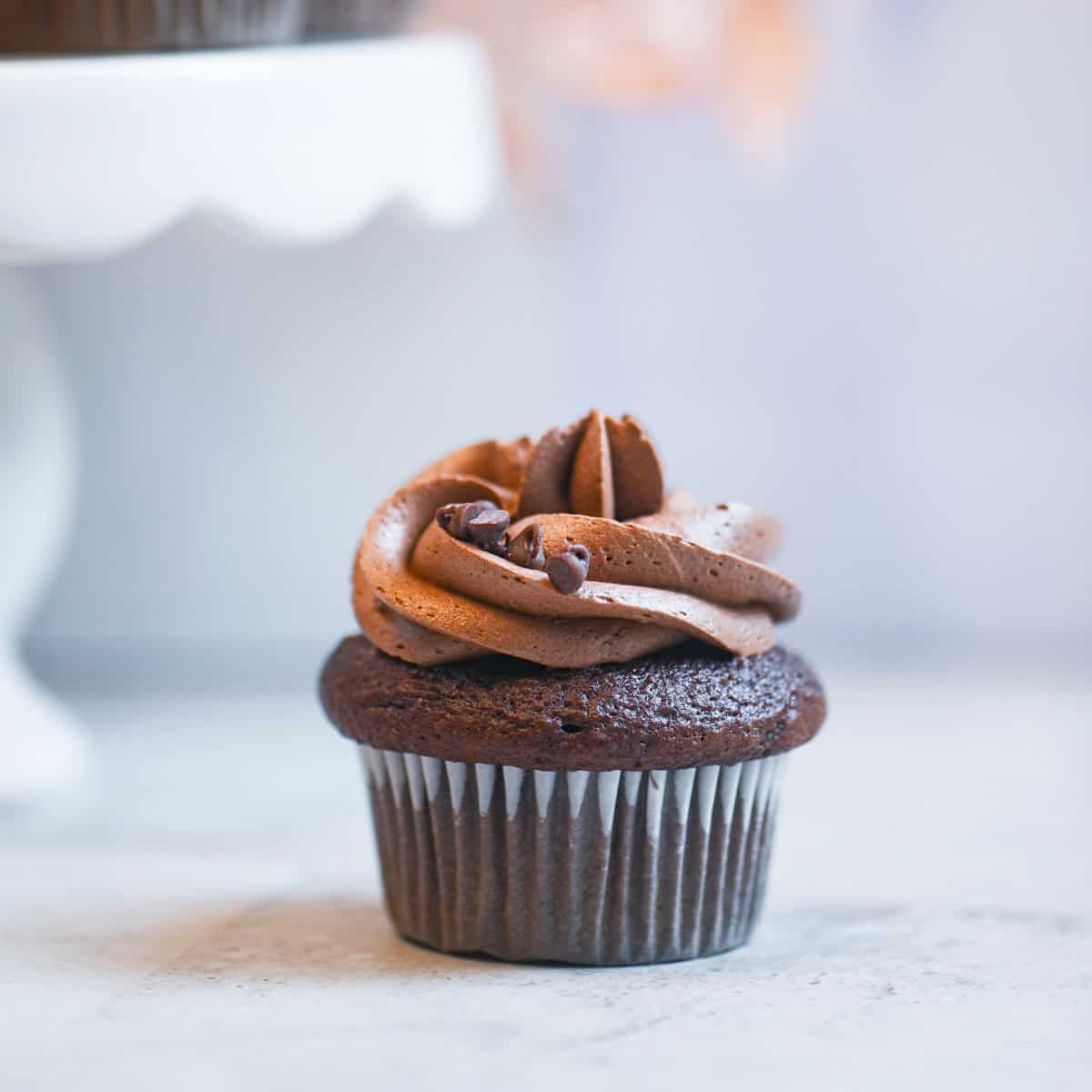 Close-up of creamy homemade chocolate buttercream frosting swirled on a cupcake.