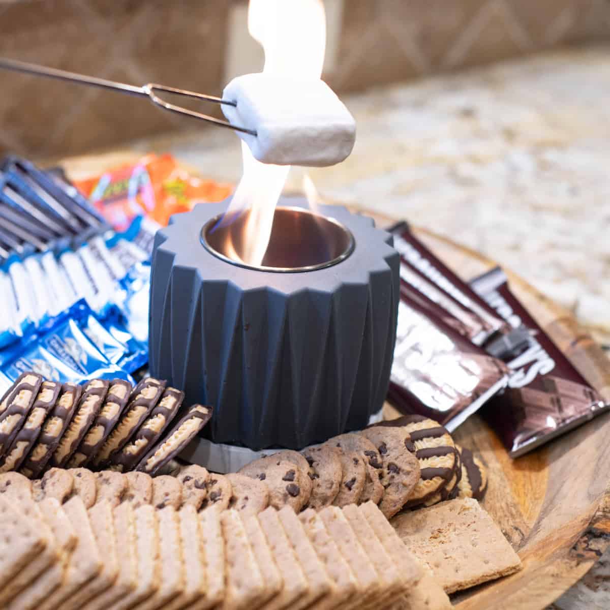 Close-up of a marshmallow roasting over a tabletop fire pit.