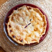 Overhead view of homemade old-fashioned blackberry pie in a pie dish in glass dish