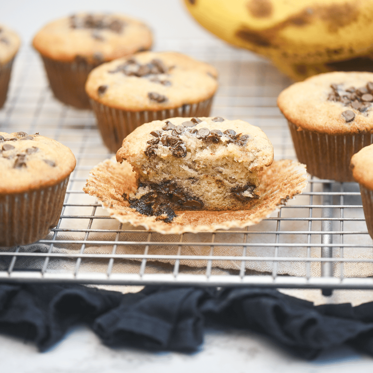 Close-up of a halved muffin with gooey chocolate chips visible inside.