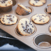 Zoomed-in view of a muffin on the pan with melted chocolate chips on top.