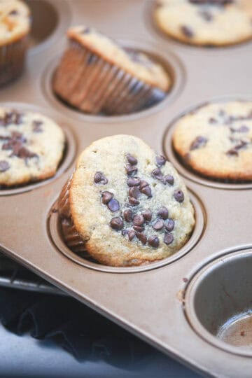 Zoomed-in view of a muffin on the pan with melted chocolate chips on top.