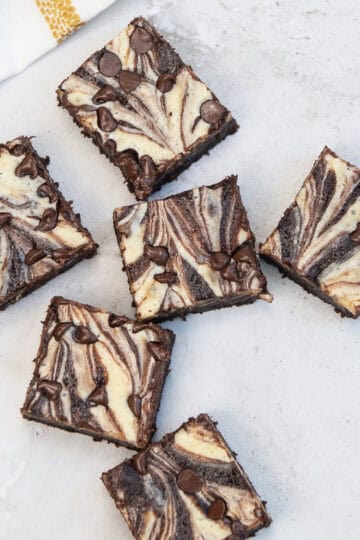 Flat lay of marbled brownies cut into squares on a kitchen counter.