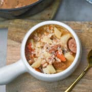 Close-up of Cajun sausage and bean soup highlighting chunks of sausage, beans, and vegetables.