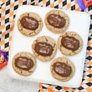 Close-up of Halloween Reeses peanut butter cookies with Reese’s pumpkins on top, showing soft texture and chocolate detail.