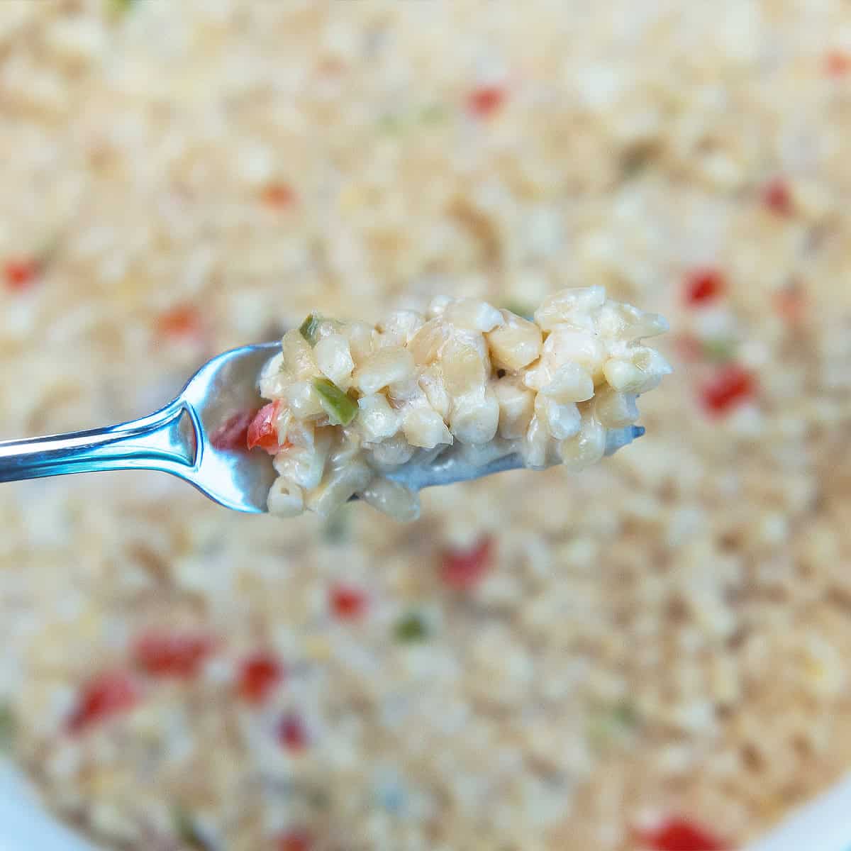 Bite of White Corn Casserole on a fork showing the creamy corn and peppers.