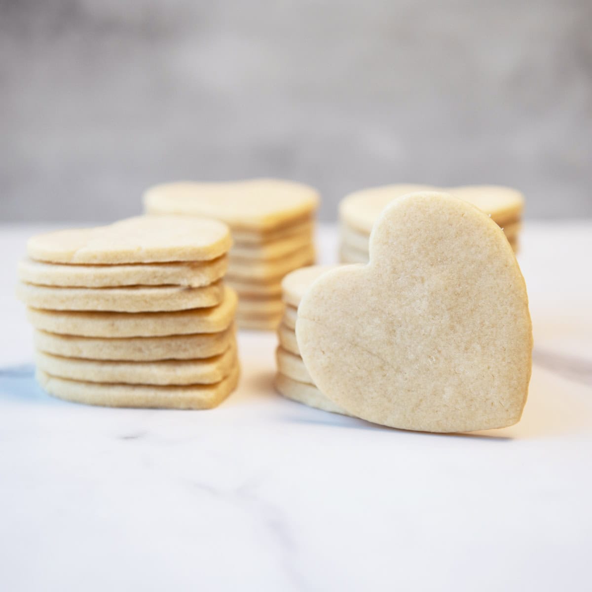 Baked sugar cookies stacked and ready to decorate with Valentine icing.
