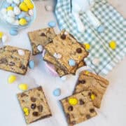 Overhead view of stacked Cadbury Egg cookie bar squares with visible chocolate chips and candy pieces.