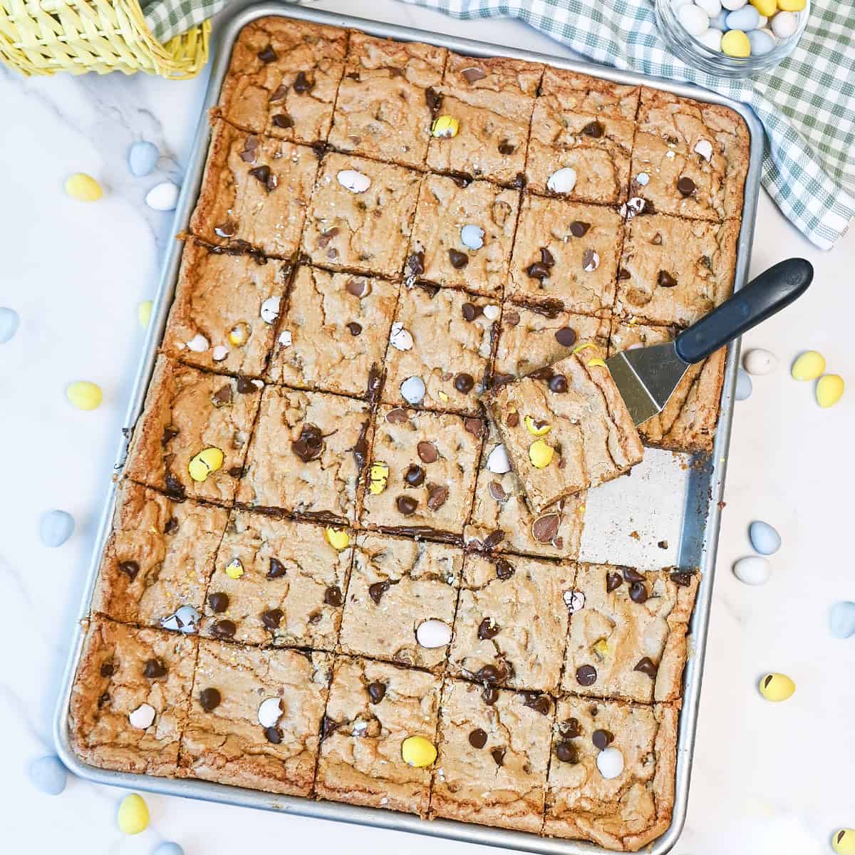 Close-up of multiple Cadbury Egg cookie bar squares showing gooey chocolate chips and soft texture.
