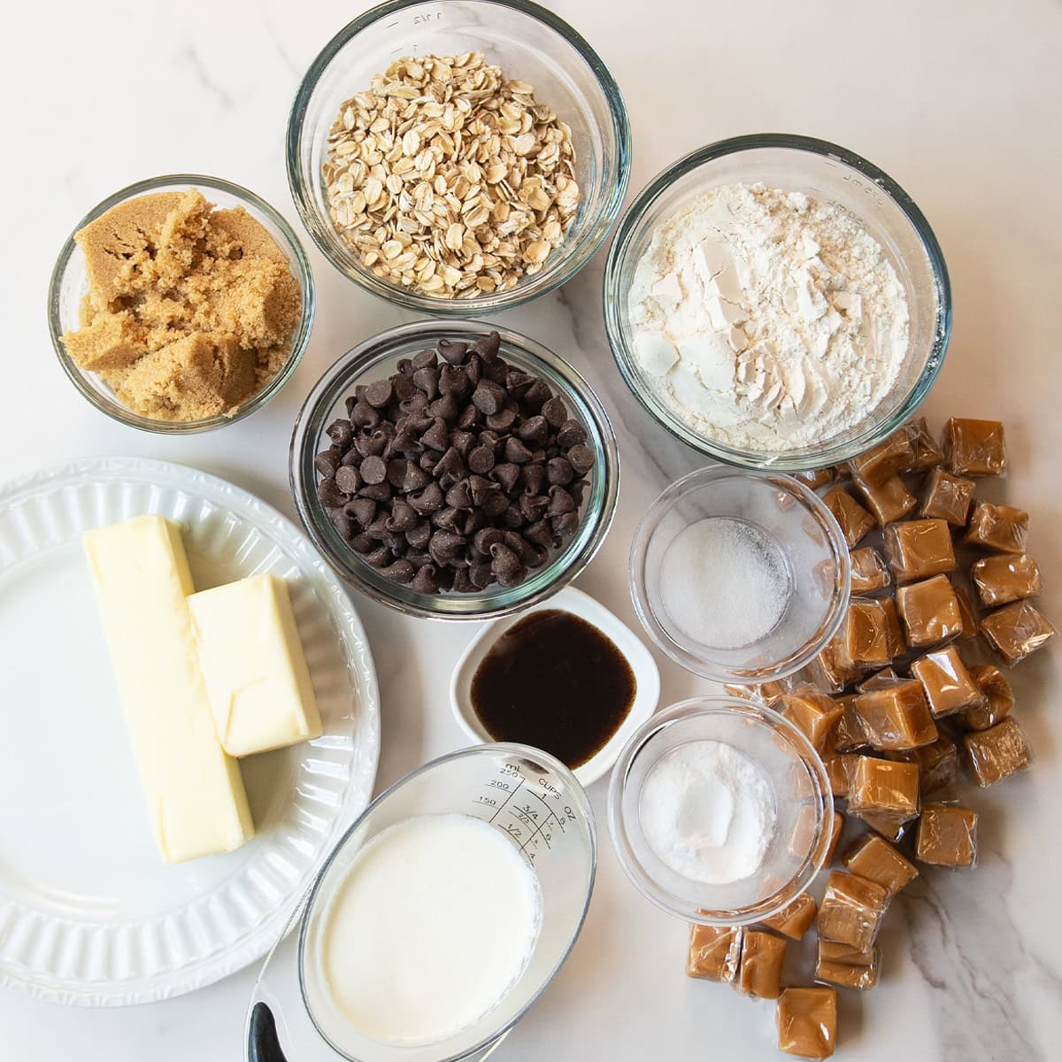 Ingredients for Carmelitas including oats, flour, butter, brown sugar, chocolate chips, and caramel.