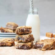 Stack of Carmelitas bars served with a glass of milk showing gooey caramel and chocolate layers.