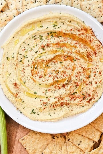 Close-up overhead view of creamy hummus with olive oil pooled in the swirls.