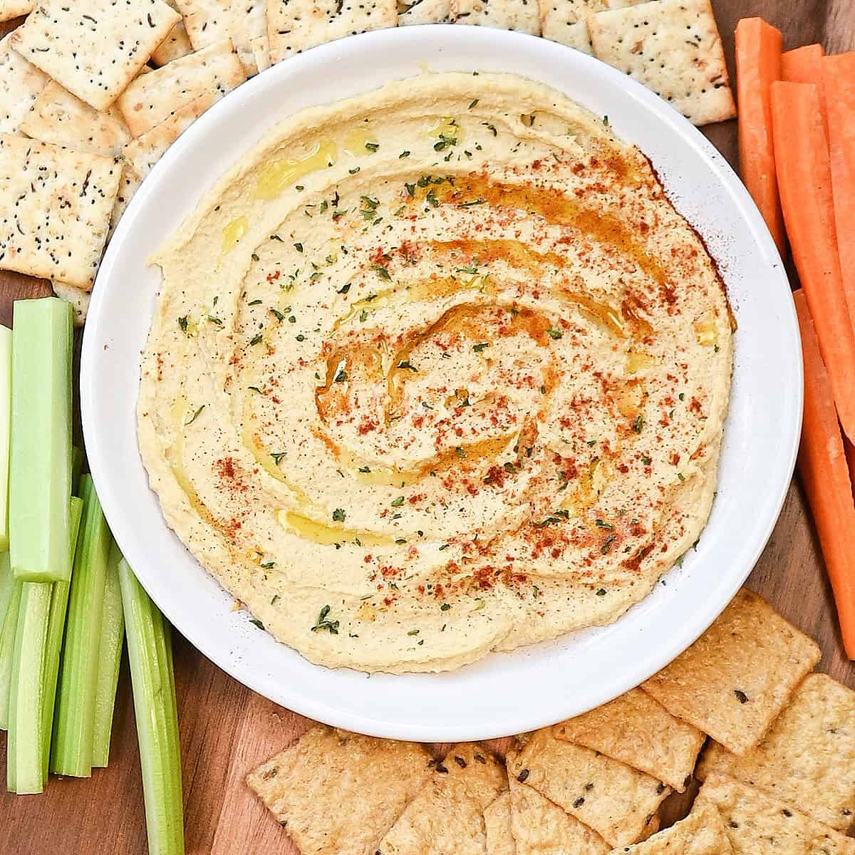 Close-up overhead view of creamy hummus with olive oil pooled in the swirls.
