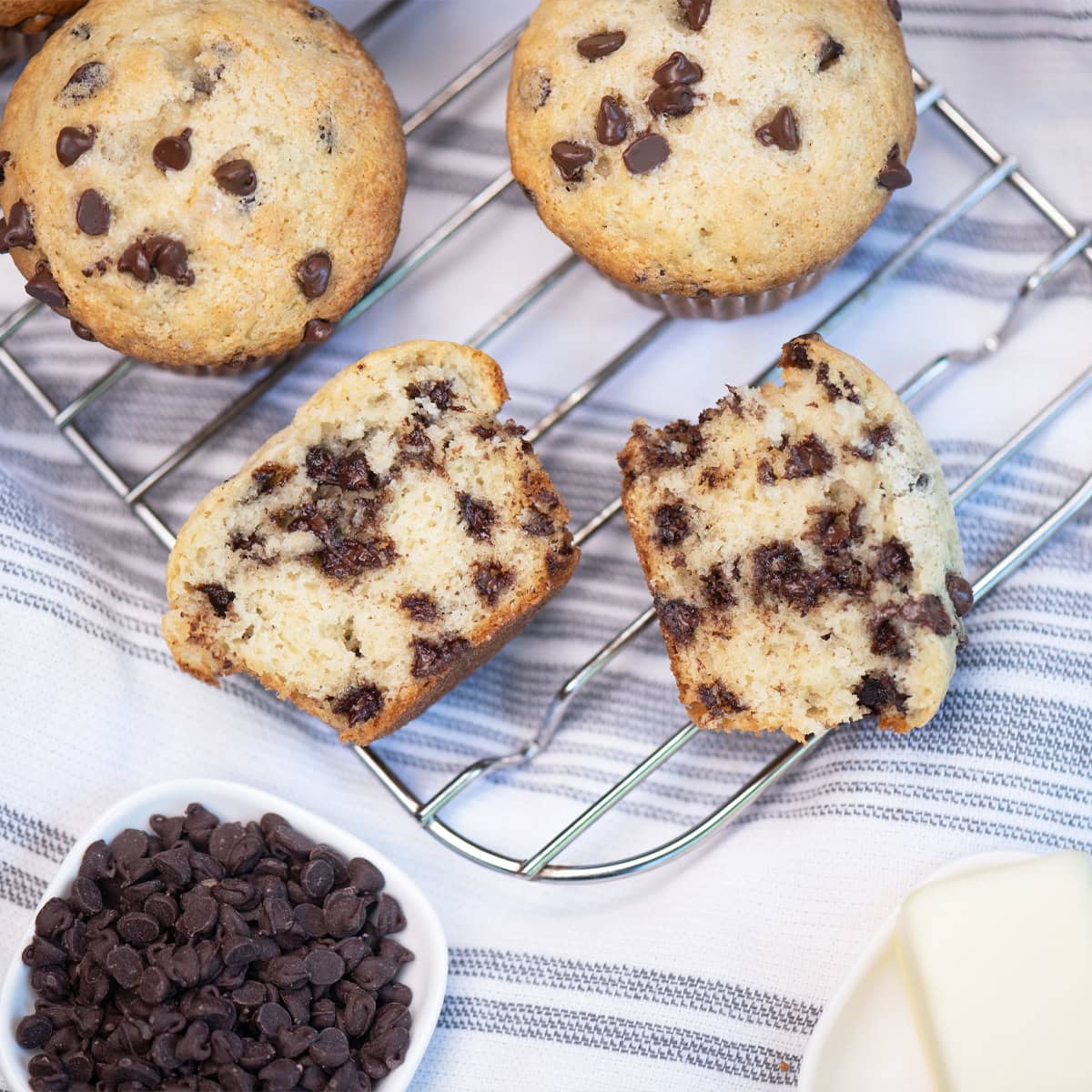 Overhead view of chocolate chip muffins with both whole and halved muffins showing texture