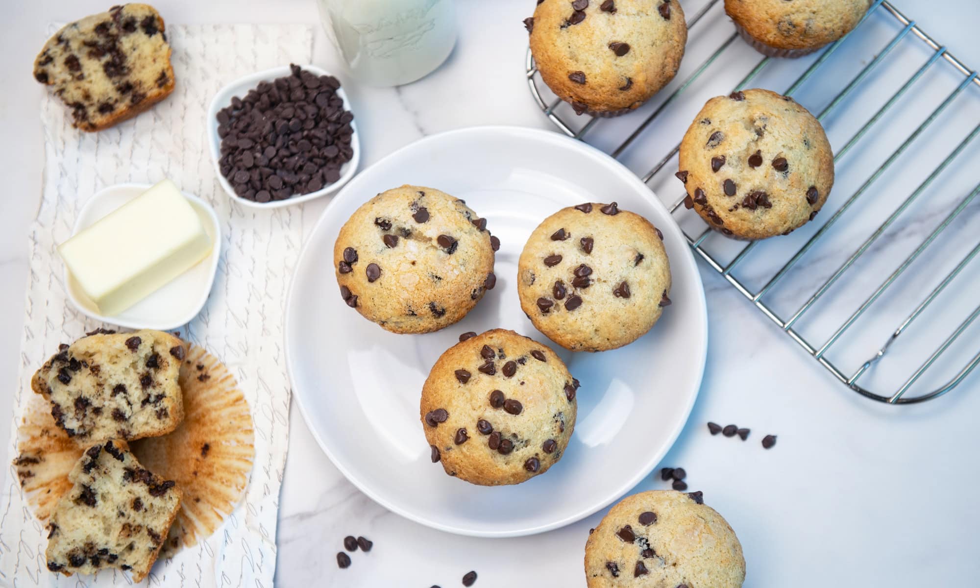 Overhead view of chocolate chip muffins with both whole and halved muffins showing texture