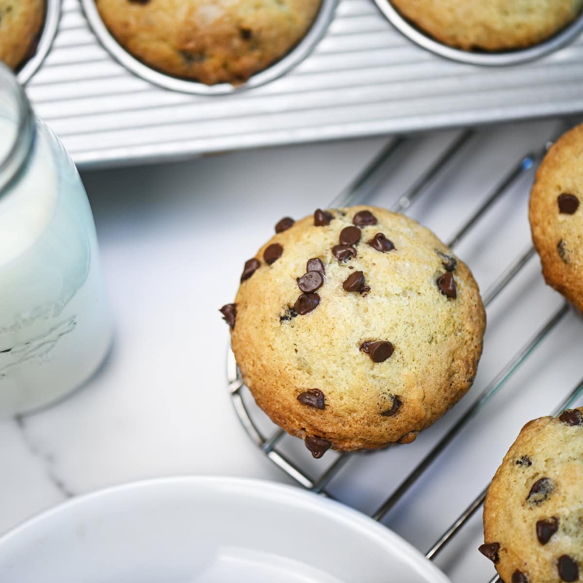 Overhead close-up of chocolate chip muffin top with golden crust and chocolate chips