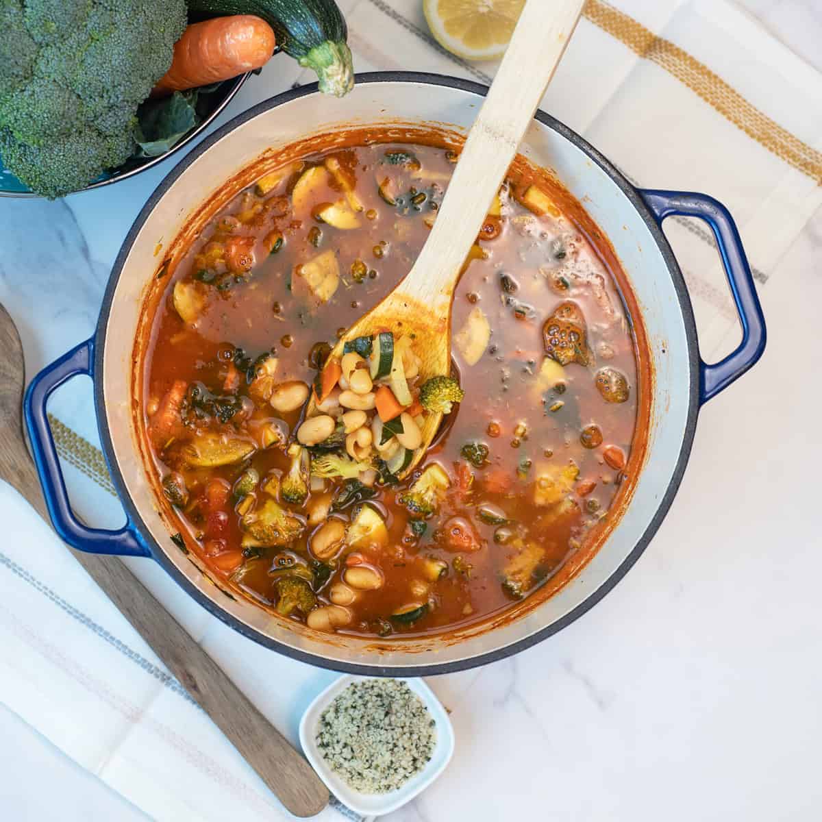 Large pot filled with healthy white bean vegetable soup loaded with fresh vegetables and cannellini beans.