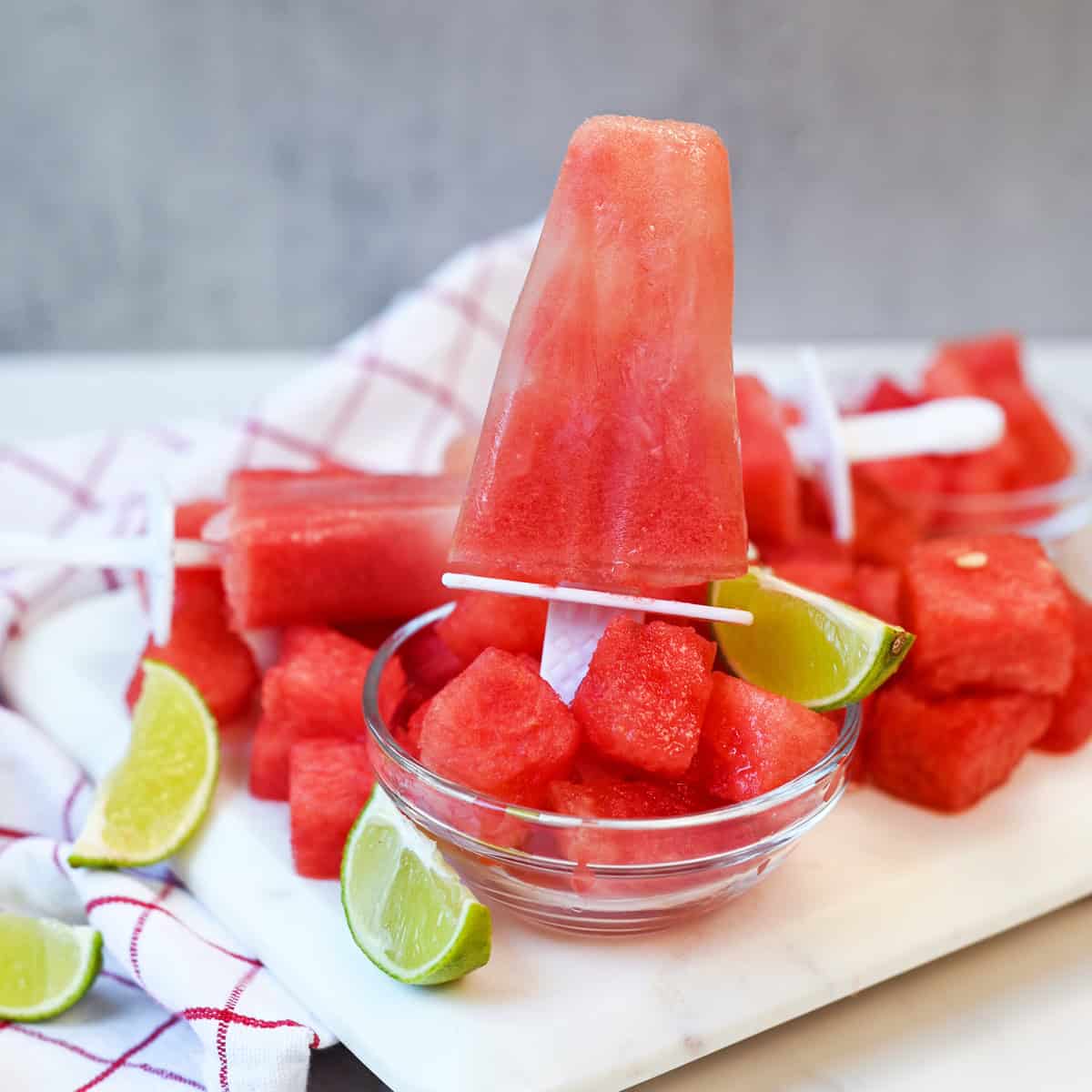 Close-up of a homemade watermelon lime popsicle showing its smooth texture and vibrant pink color.