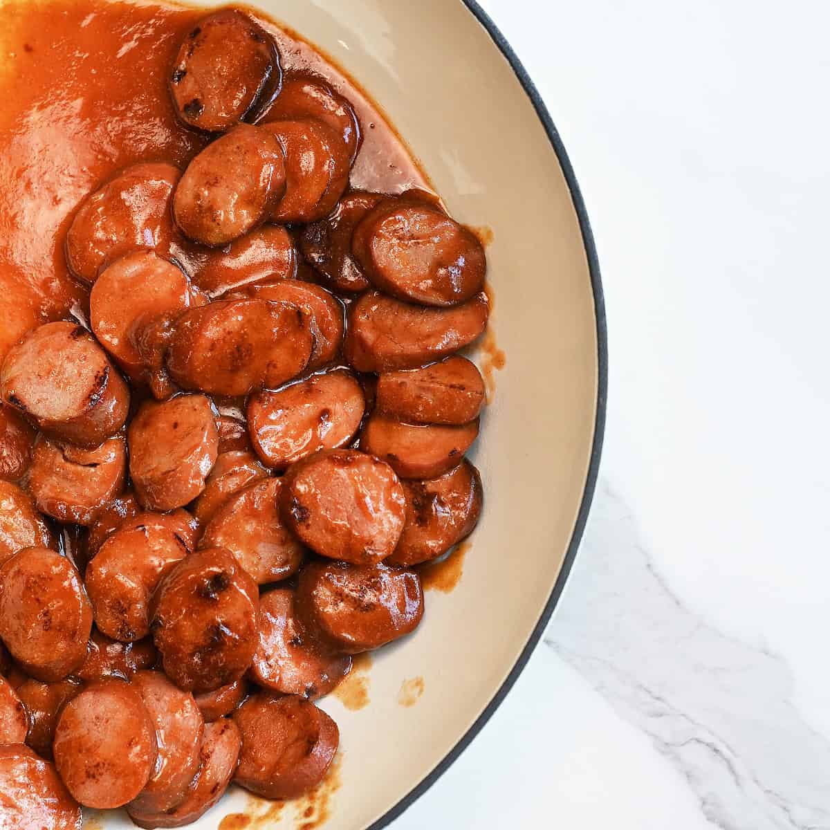 BBQ Sausages in cream skillet ready to serve with no toothpicks